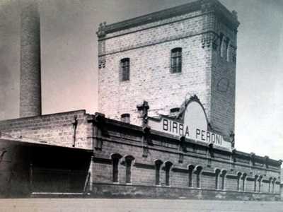 La fabbrica, costituita da edifici in pietra e alte ciminiere...